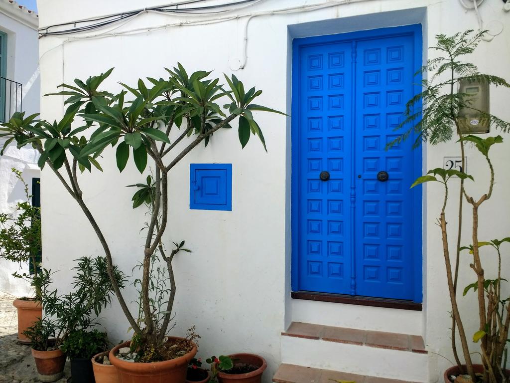 Fachada exterior de Casa Purica mostrando la puerta azul de entrada